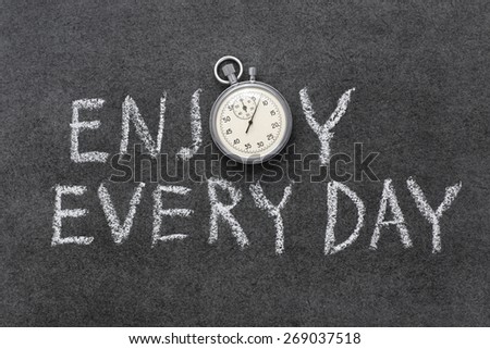 enjoy every day phrase handwritten on chalkboard with vintage precise stopwatch used instead of O