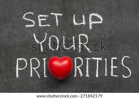 set up your priorities phrase handwritten on blackboard with heart symbol instead of O