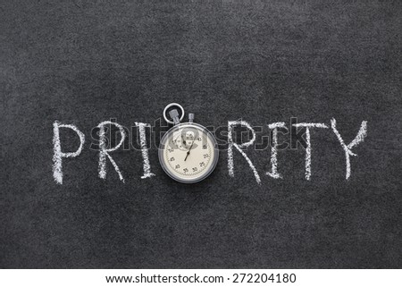priority word handwritten on chalkboard with vintage precise stopwatch used instead of O