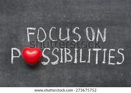 focus on possibilities phrase handwritten on blackboard with heart symbol instead of O