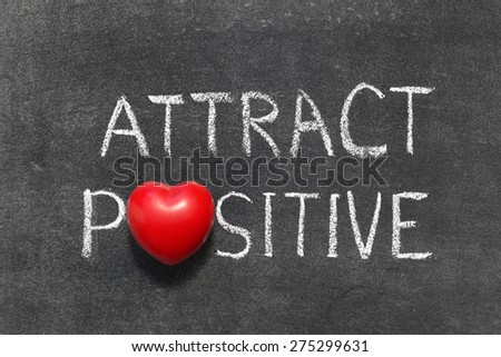 attract positive phrase handwritten on blackboard with heart symbol instead of O