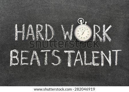 hard work beats talent phrase handwritten on chalkboard with vintage precise stopwatch used instead of O