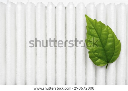 air purity concept with small fresh green leaf on white filter surface