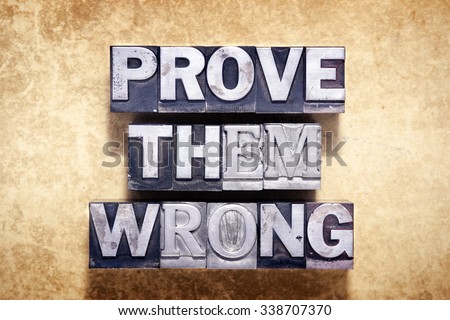 prove them wrong phrase made from metallic letterpress type on grunge cardboard background