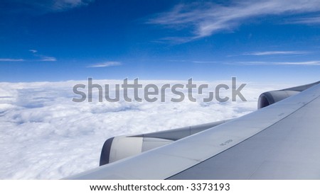 view from airplane window to the bright cloudy sky background