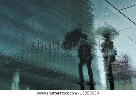 rainy pavement reflection of walking couple in Tokyo, Japan during rainy season which usually takes time in June