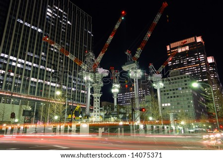 construction place in center of Tokyo among huge skyscrapers by night