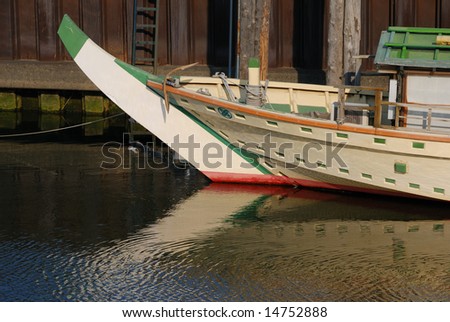 traditional Japanese Boat for tourists with scenic water reflection close to pier