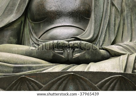detailed image of Buddha\'s sculpture hands in peaceful pose; focus on hands