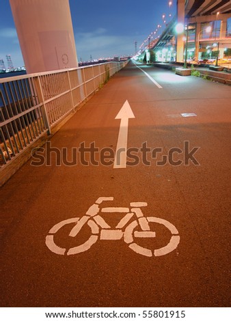 night image of bicycle road going faraway on the Tokyo bay embankment; focus on bicycle sign