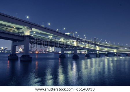 bridge structure over night bay waters with scenic illumination in Tokyo, Japan