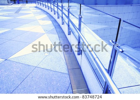 tiled floor, metallic handrails and glass fence fragments of modern urban square