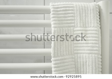 light soft image of white bath towel hanged up on the  radiator