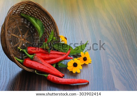 hot pepper with flowers in a basket on the table