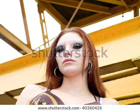Attractive young woman with red hair posing in an industrial area