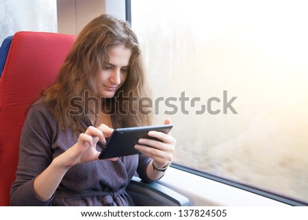 A woman with a tablet pc on a train ride