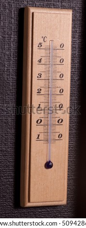 Old thermometer measuring in celsius. On the black wall.