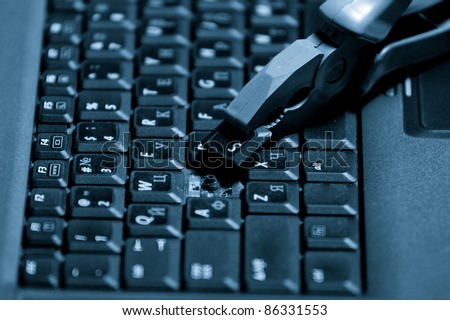 A broken laptop with a pliers. Closeup