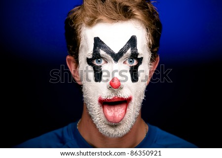 A man with clown makeup on his face  looking into the camera