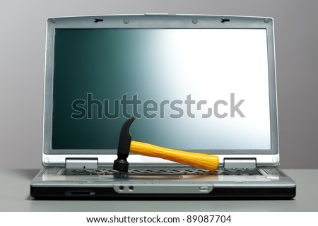 laptop with a hammer on the screen, closeup
