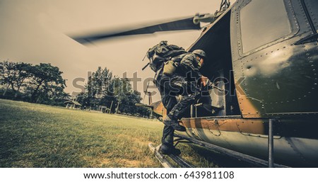 Soldiers boarding a military helicopter , Soldiers running through a sandstorm.