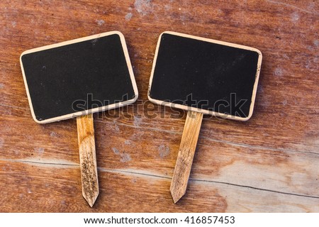 Two blank blackboard labels on wooden table