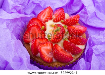 cake with strawberries and custard in a box for shipping. on a light wooden background. top view.Portion pastries