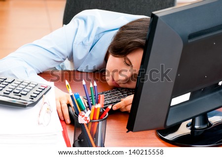 Woman at the office sleeping at workplace on the table
