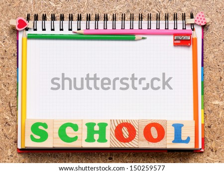 Frame from school accessories and wooden toy cubes with letters