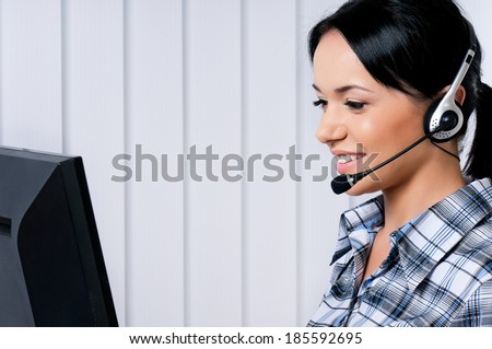 Smiling female helpline operator with headphones giving a consultation