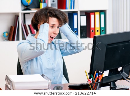 Surprised business woman working on computer at her office