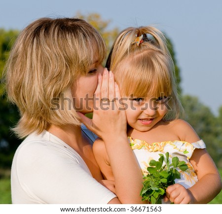Beautiful daughter listening to her mother\'s secret whispers