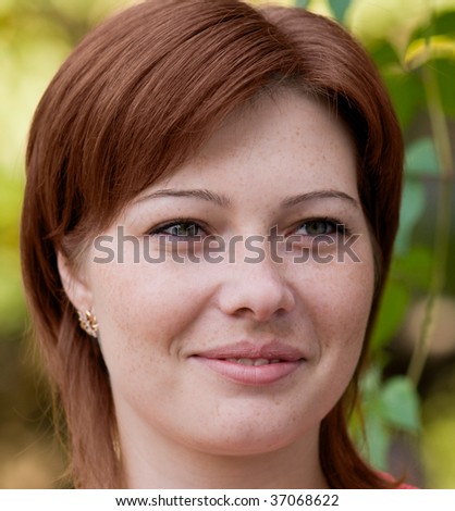 Portrait of a young beautiful woman with freckles