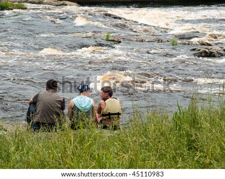 United family - father, mother, son - on river bank