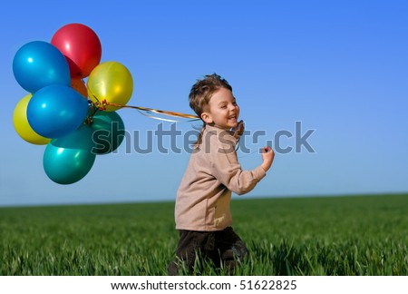 Happy child with balloons running on the spring field