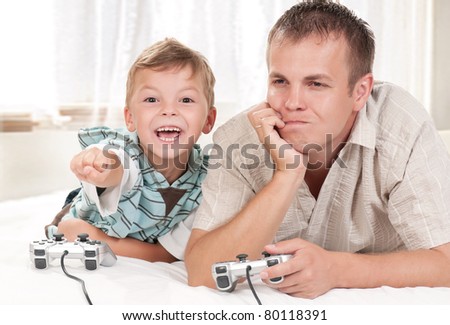 Happy family - father and child playing a video game