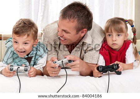 Happy family - father and children playing a video game