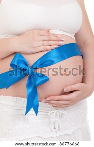 Pregnant belly with blue ribbon - isolated over a white background. Third trimester.