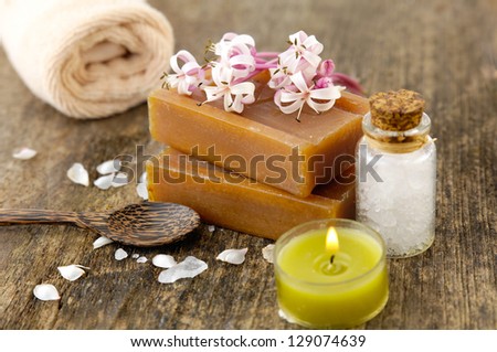 Handmade soap with spring flower, towel, Bath Salts in a Glass Bottle on old wooden background