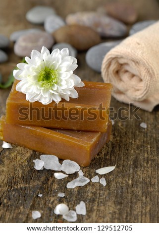 flower on soap, towel, soap ,stones on old wooden