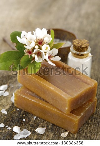 Tropical Spring flower with soap, salt in bowl on old wooden