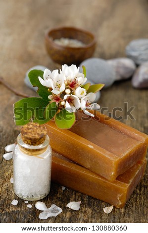 flower on soap, stones, salt in glass on old wooden