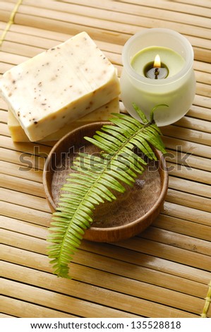 fern ,salt in bowl and candle ,handmade soap on wooden mat