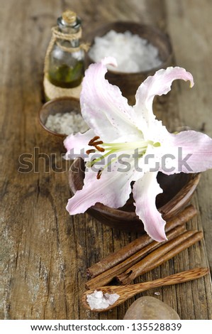 Aromatic spa set with salt in spoon ,massage oil , lily flower in bowl