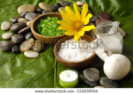 spa supplies with yellow sunflower. salt in bowl ,image of tropical spa.