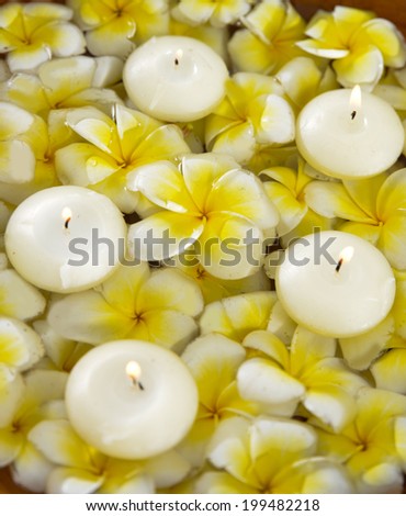 Top view Many yellow and whit frangipani with five candle in the water