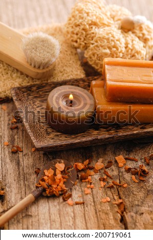Handmade soap, candle, soap ,spoon ,brush , flower petals on old wood