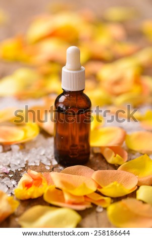 Set of roses petals with massage oil old wooden board