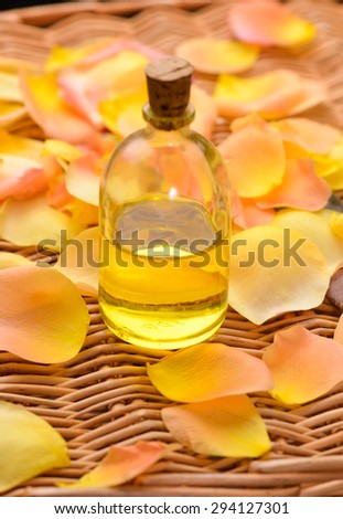 Orange rose and petals with massage oil on bamboo mat