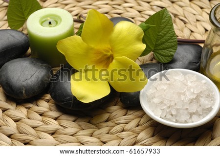 burning candles and massage stones with bowl on salt on woven mat, texture